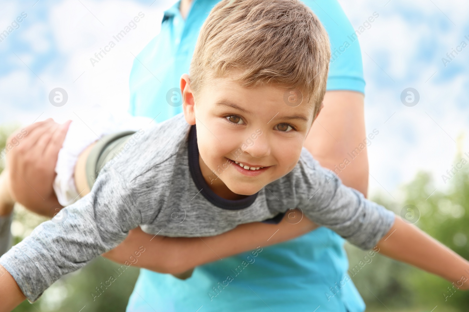 Photo of Man playing with his child outdoors. Happy family