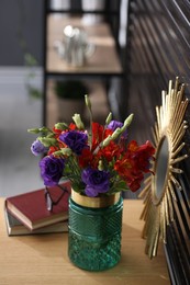 Glass vase with fresh flowers on wooden table