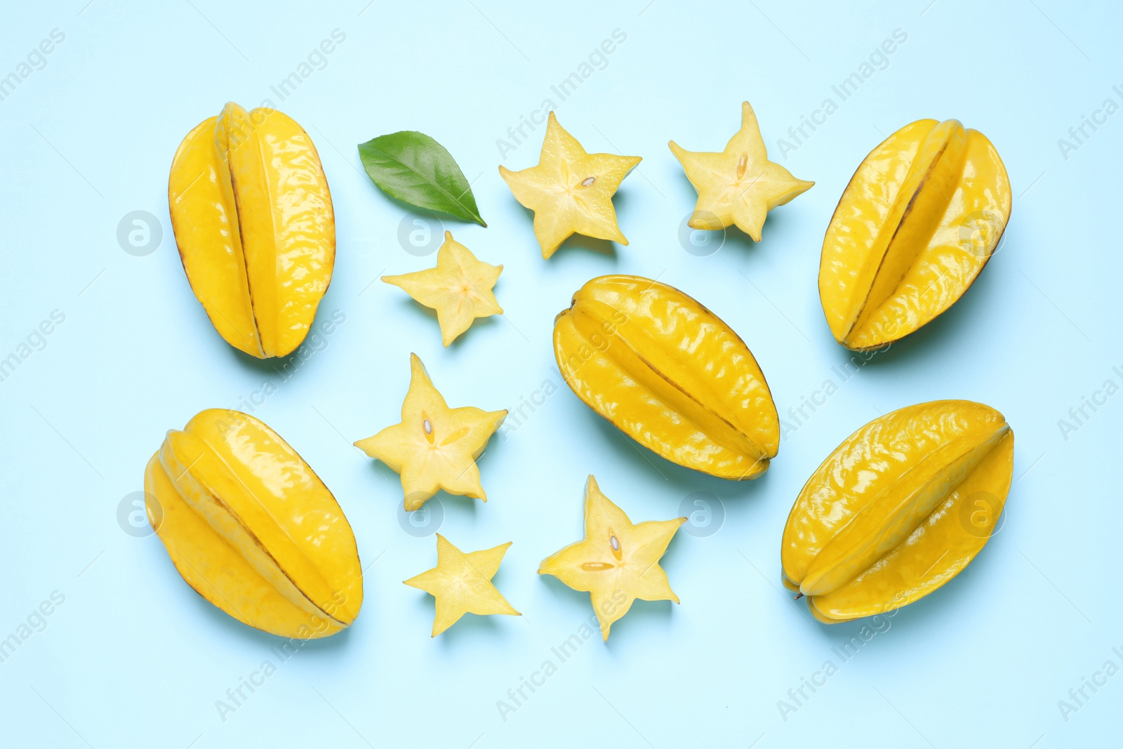 Photo of Delicious carambola fruits on light blue background, flat lay