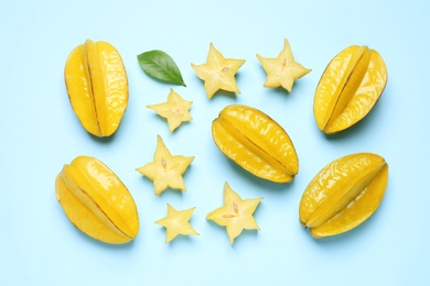 Delicious carambola fruits on light blue background, flat lay