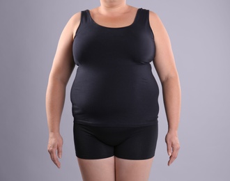 Photo of Fat woman on grey background, space for text. Weight loss