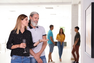 Senior man and woman at exhibition in art gallery