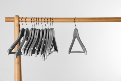 Wooden rack with clothes hangers on white background