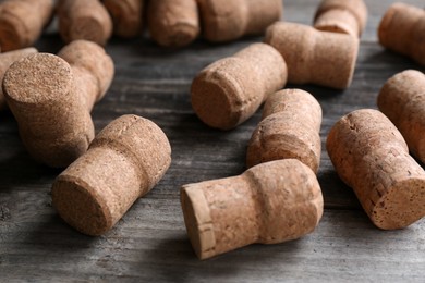 Photo of Sparkling wine bottle corks on wooden table, closeup