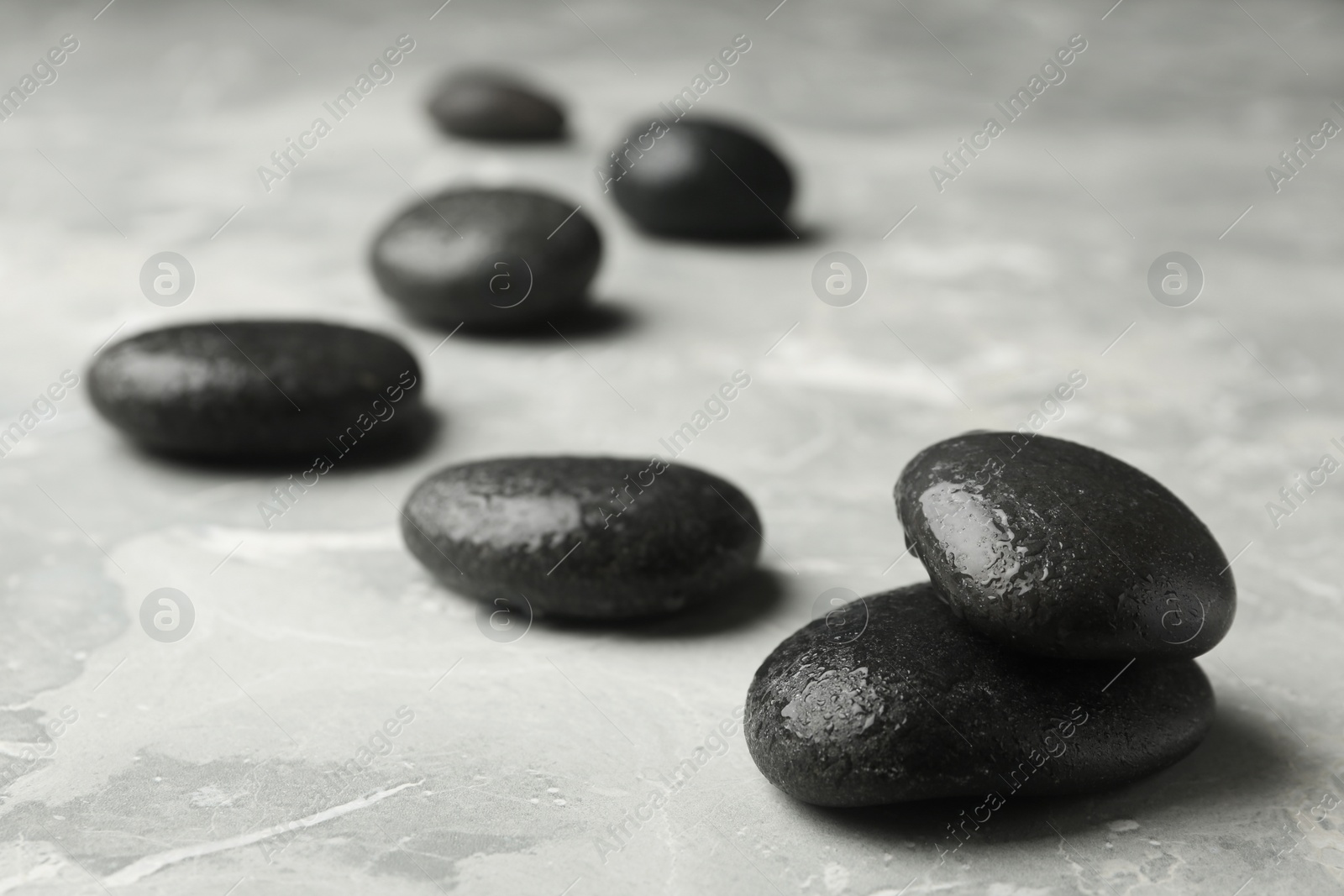 Photo of Wet spa stones on grey background. Space for text