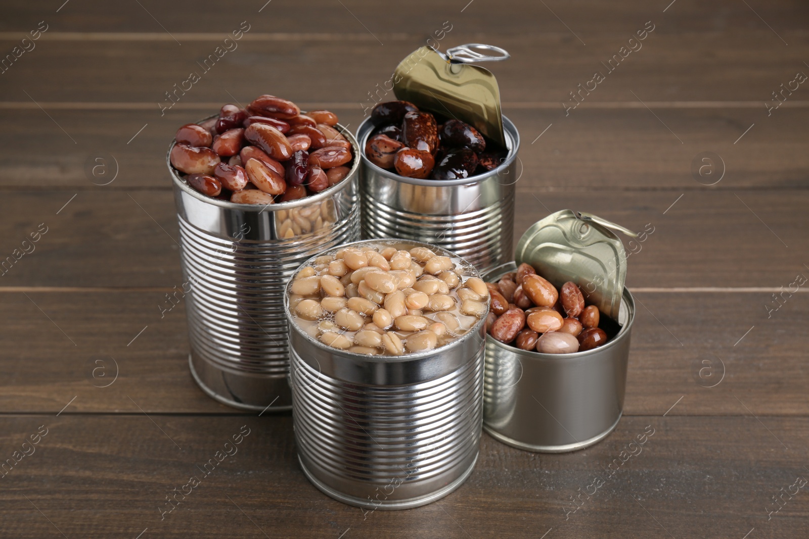 Photo of Tin cans with kidney beans on wooden table