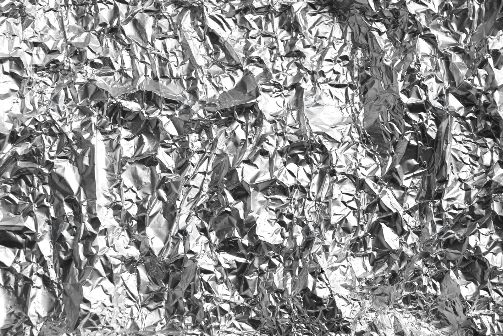 Photo of Crumpled silver foil as background, closeup view