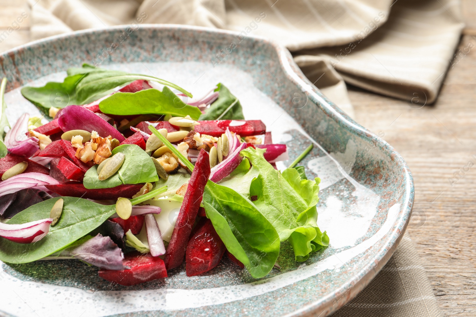 Photo of Plate with delicious beet salad on table, closeup