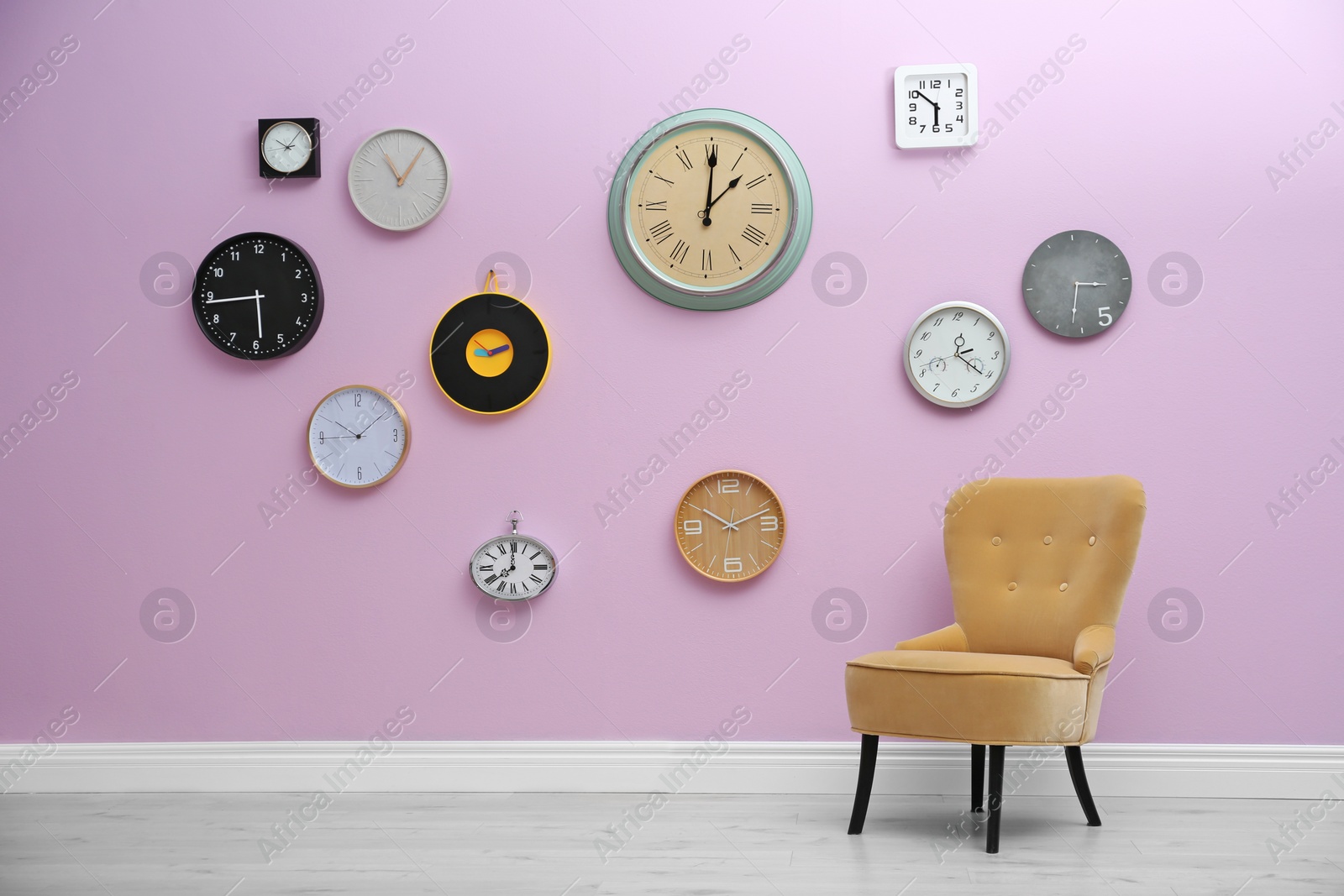 Photo of Room interior with many different clocks on wall. Time of day