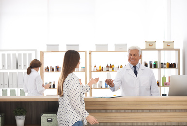 Photo of Pharmacist giving medicine to customer in drugstore