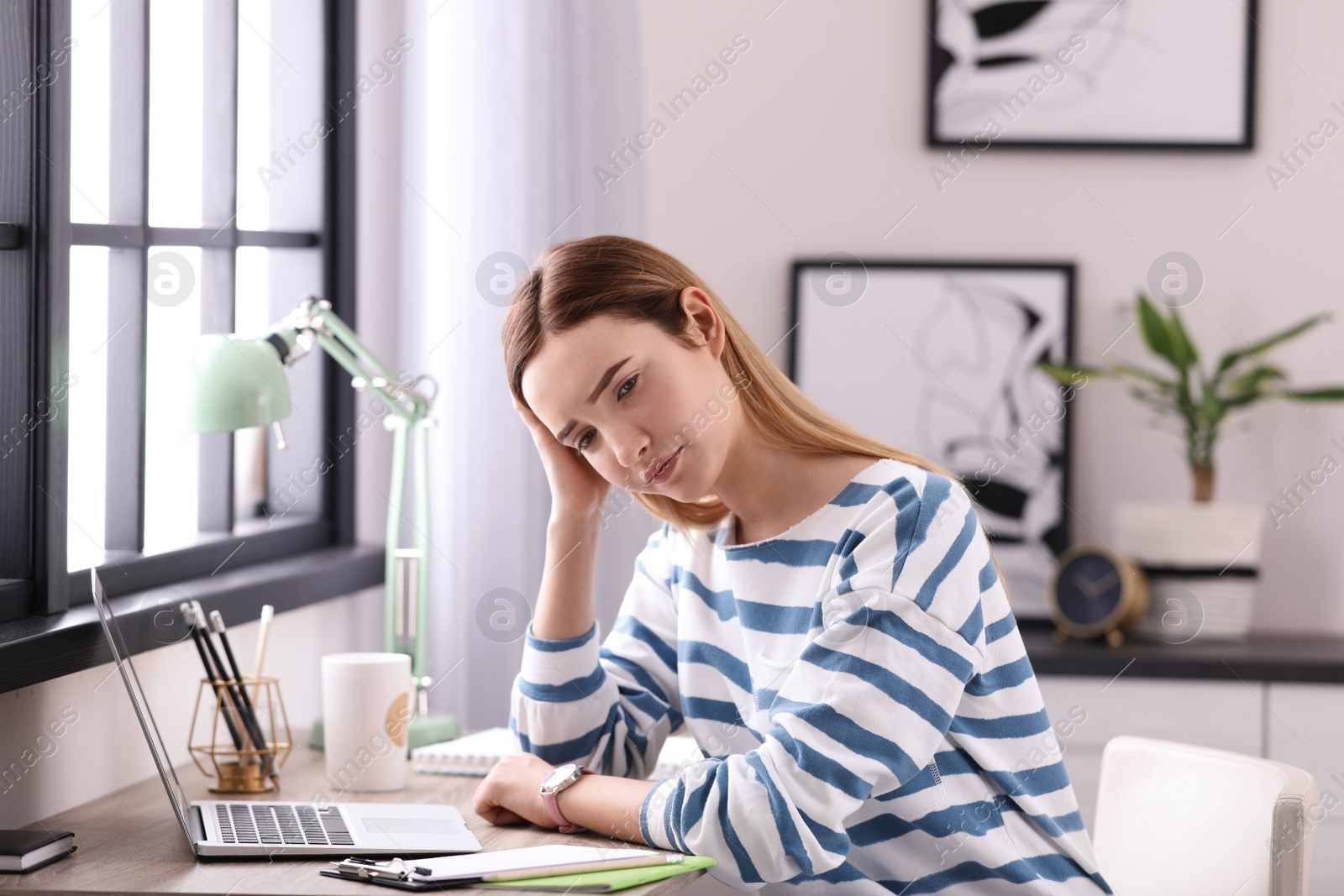 Photo of Emotional teenage girl at table in her room