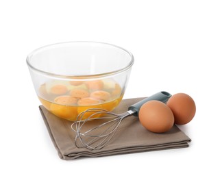 Photo of Whisk, raw eggs and bowl with yolks isolated on white