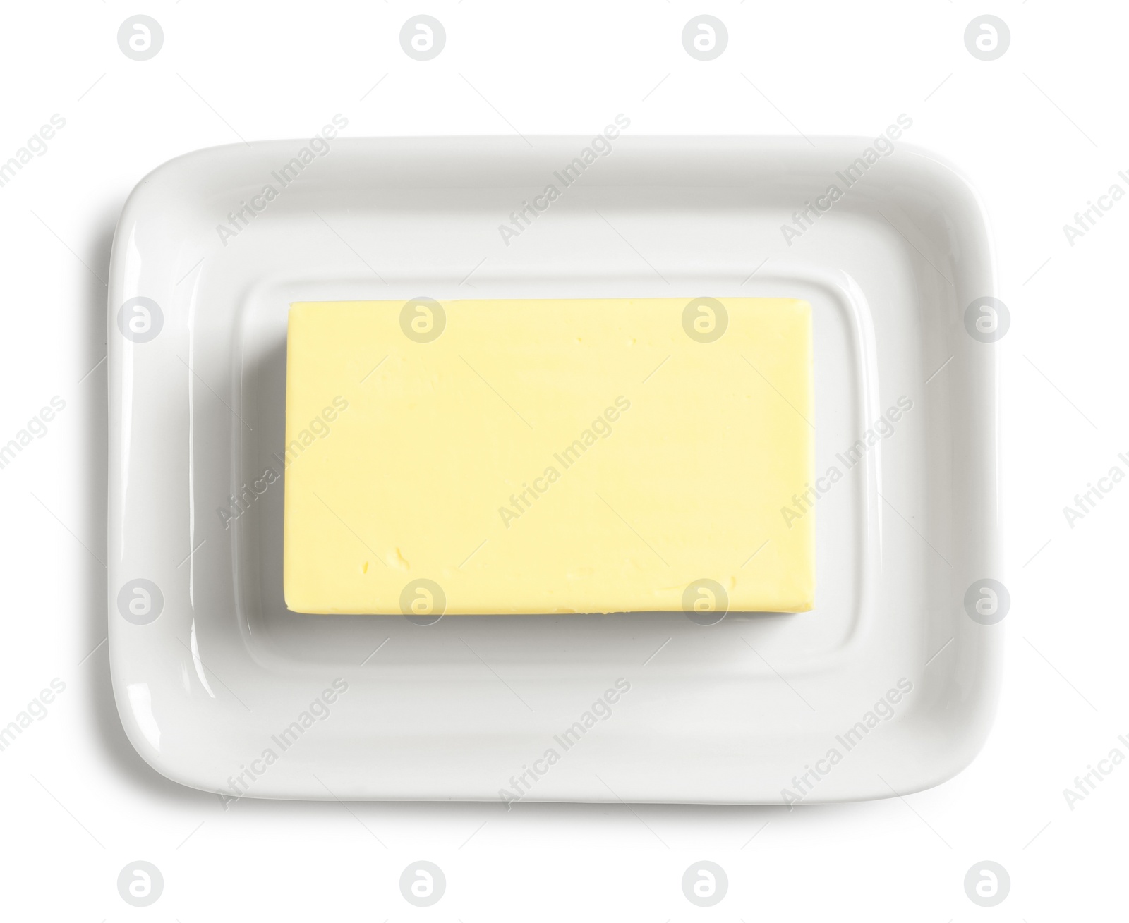 Photo of Ceramic dish with block of fresh butter on white background, top view