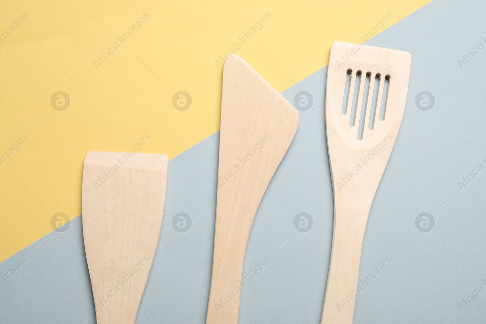 Photo of Different wooden spatulas on color background, flat lay