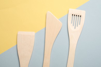 Photo of Different wooden spatulas on color background, flat lay