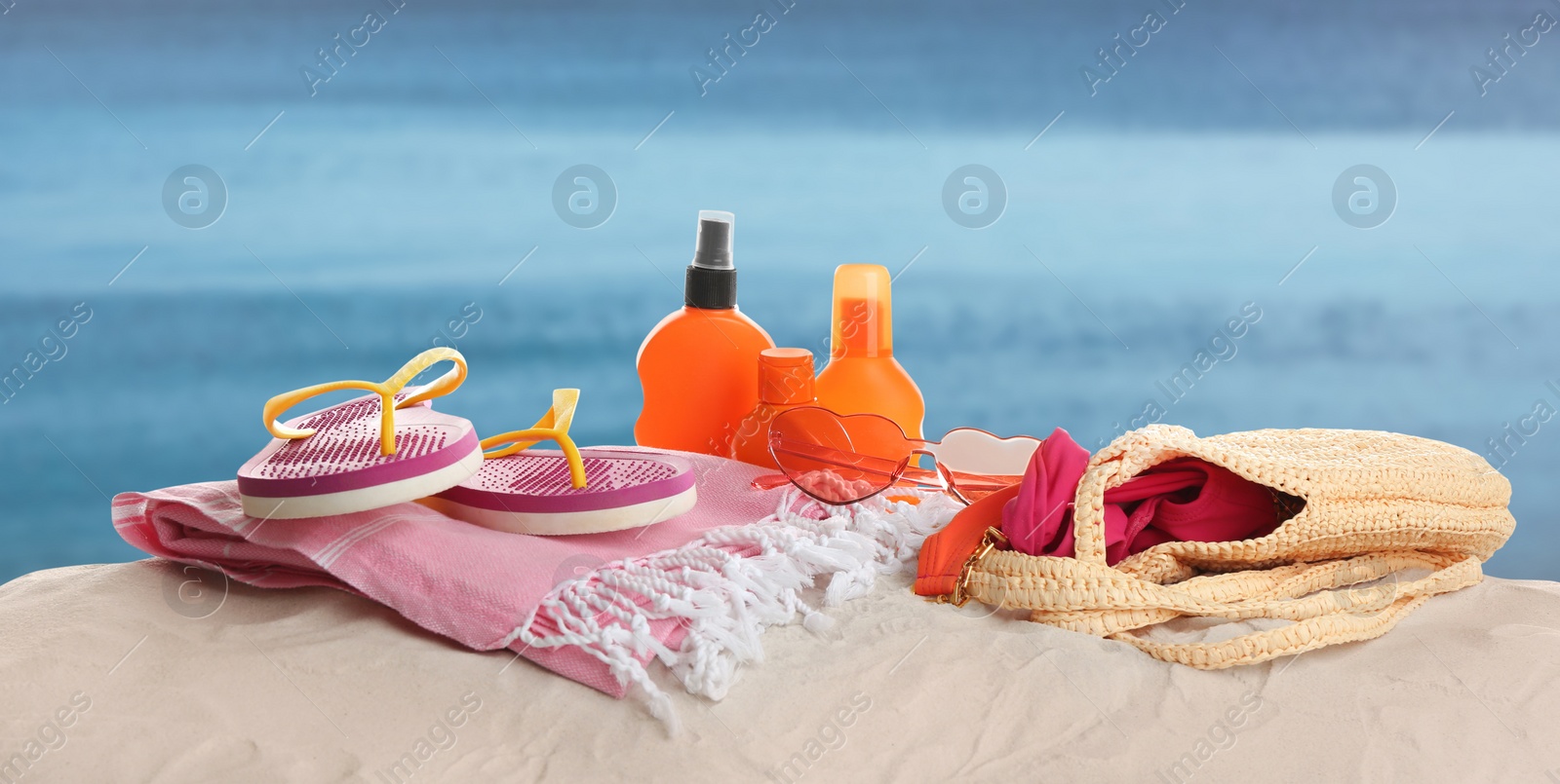 Image of Different beach accessories on sand near sea. Banner design