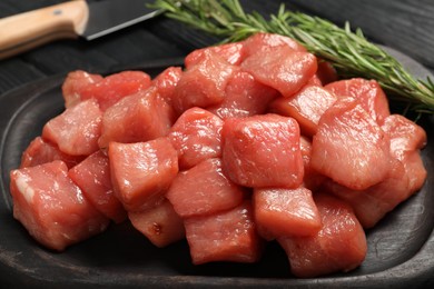 Photo of Cooking delicious goulash. Raw beef meat and rosemary on table, closeup