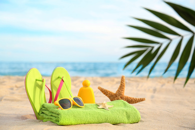 Different stylish beach objects and starfish on sand near sea