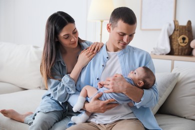 Photo of Happy family with cute baby on sofa at home