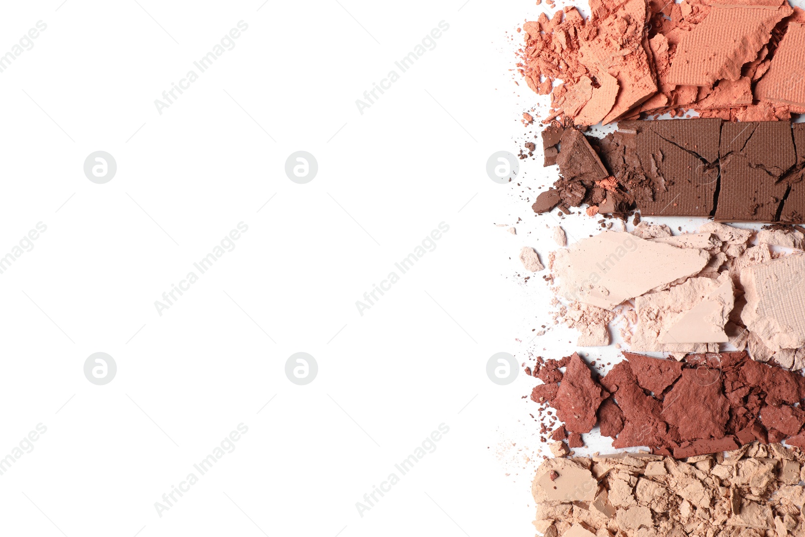 Photo of Swatches of crushed eye shadows on white background, top view. Space for text