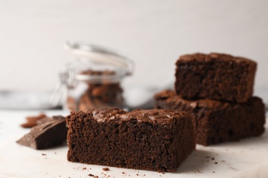 Photo of Serving board with fresh brownies on table against light background, space for text. Delicious chocolate pie