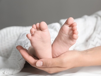 Photo of Mother holding her baby, closeup on feet