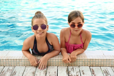 Photo of Happy girls with sunglasses in swimming pool on sunny day