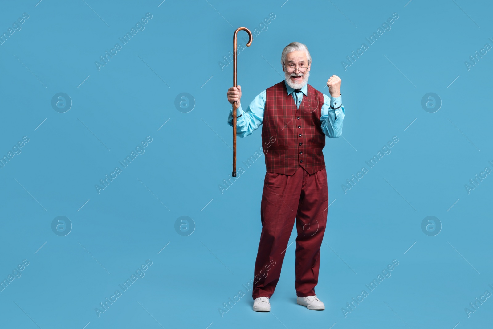 Photo of Emotional senior man with walking cane on light blue background