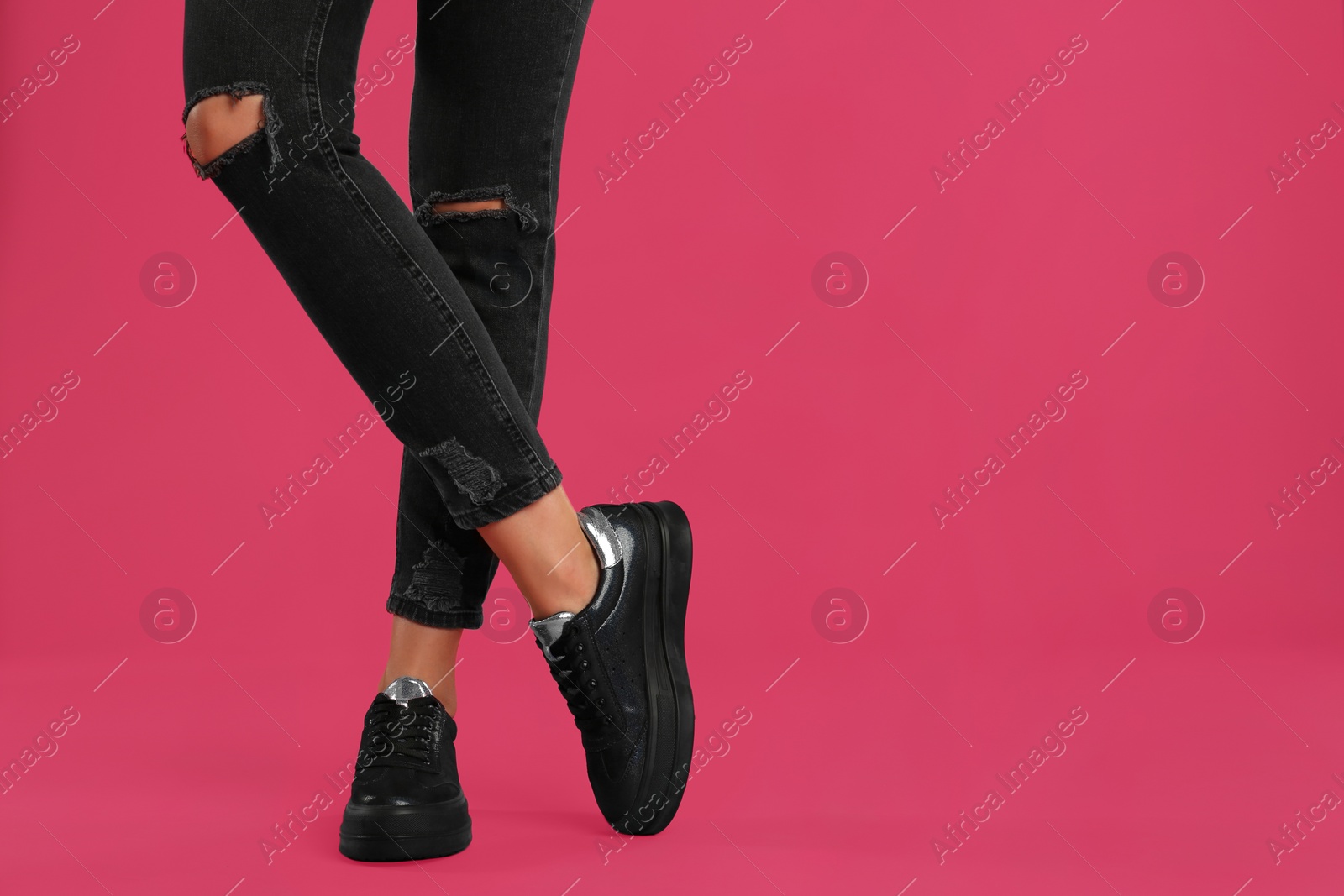 Photo of Woman wearing shoes on pink background, closeup. Space for text