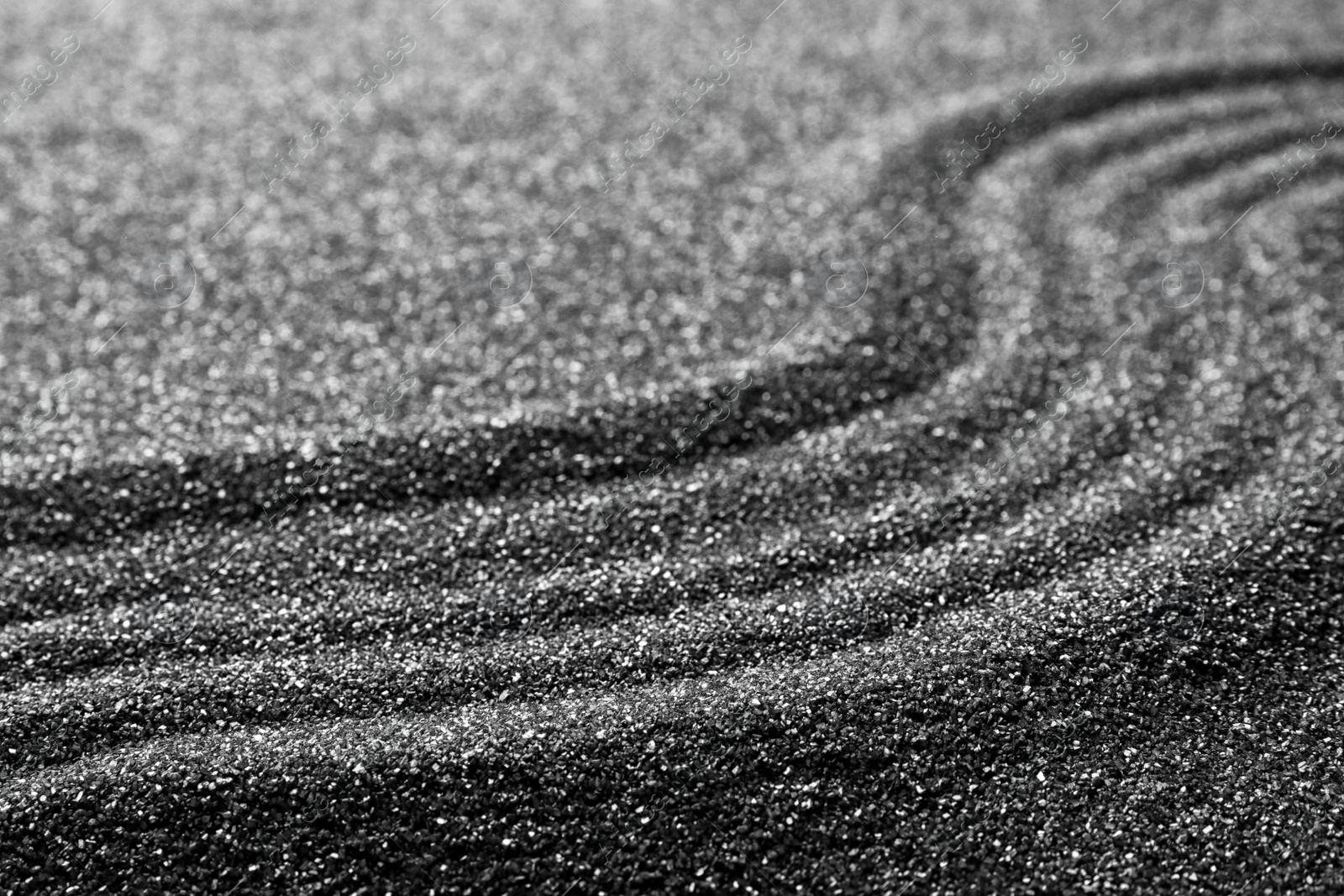 Photo of Pattern on decorative black sand, closeup. Zen and harmony