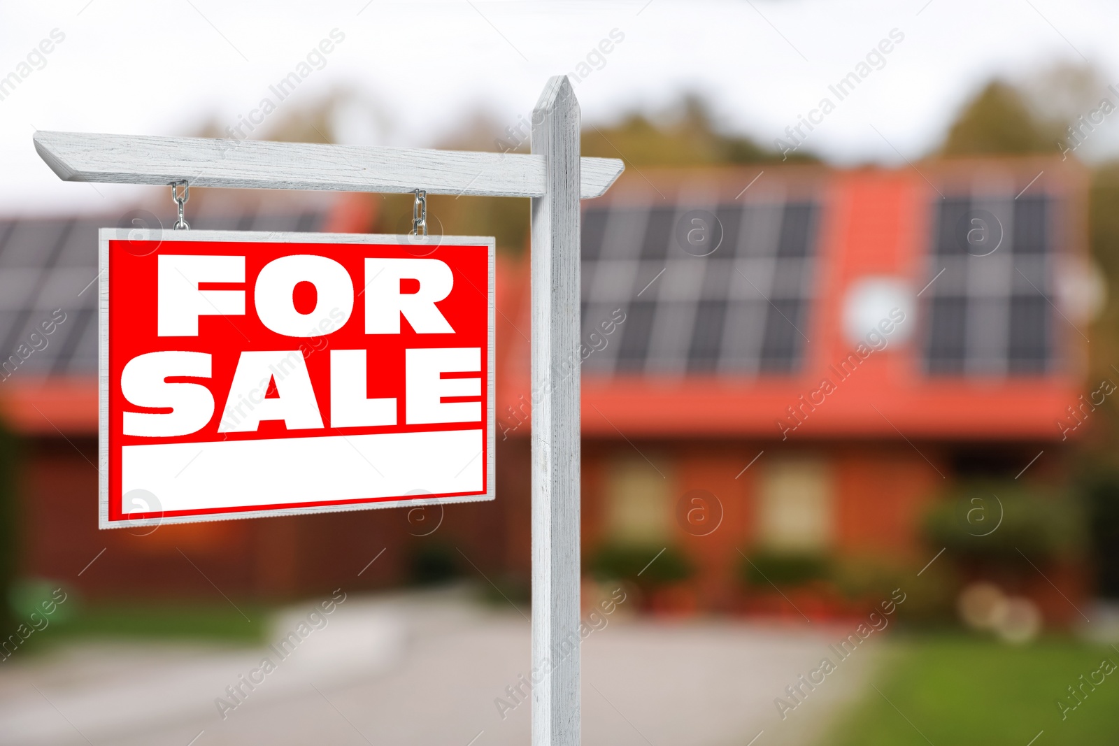 Image of Sale sign near beautiful house outdoors. Red signboard with words