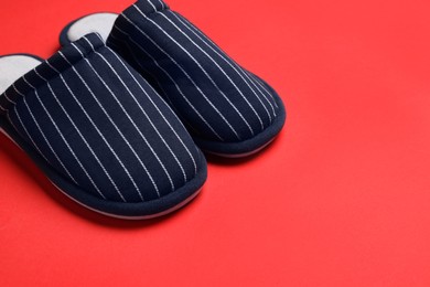 Photo of Pair of stylish slippers on red background, space for text
