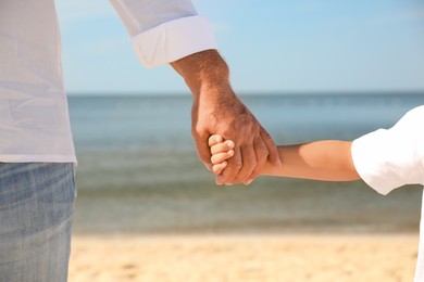 Photo of Little boy with grandfather on sea beach, closeup