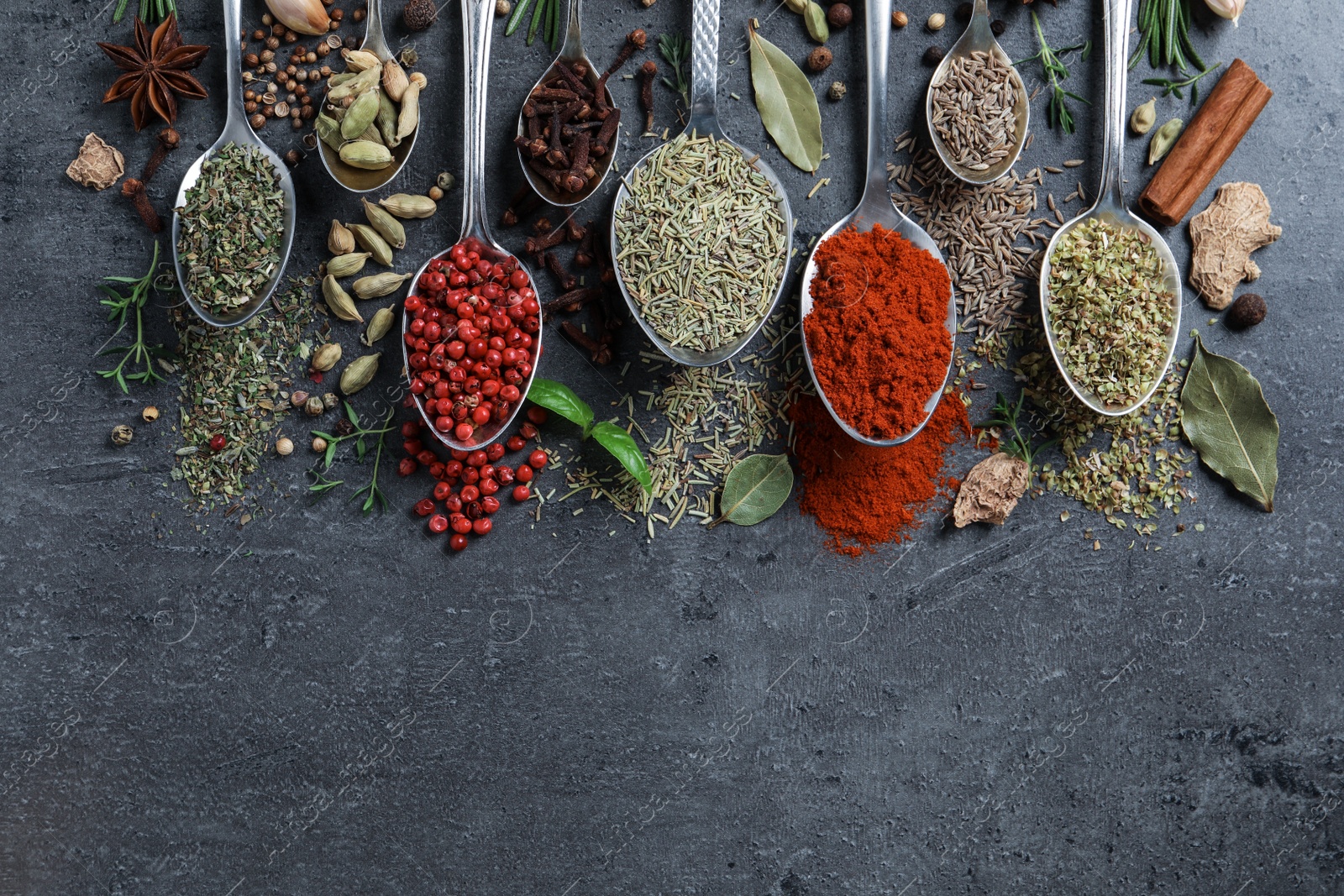 Photo of Flat lay composition with different natural spices and herbs on black table, space for text