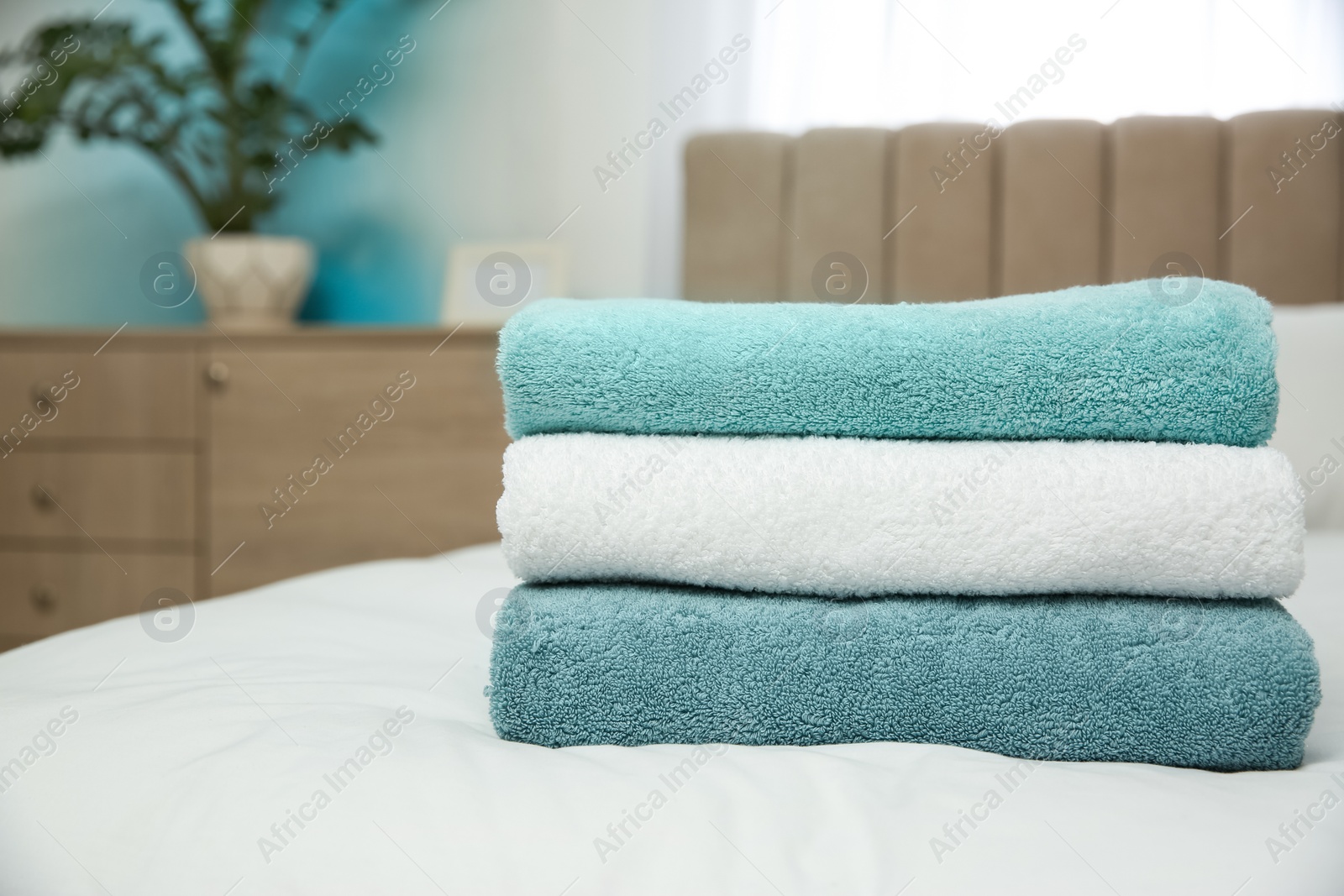 Photo of Soft clean towels on bed at home