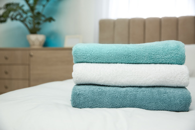 Soft clean towels on bed at home