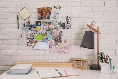 Photo of Stylish workplace with stationery and vision board