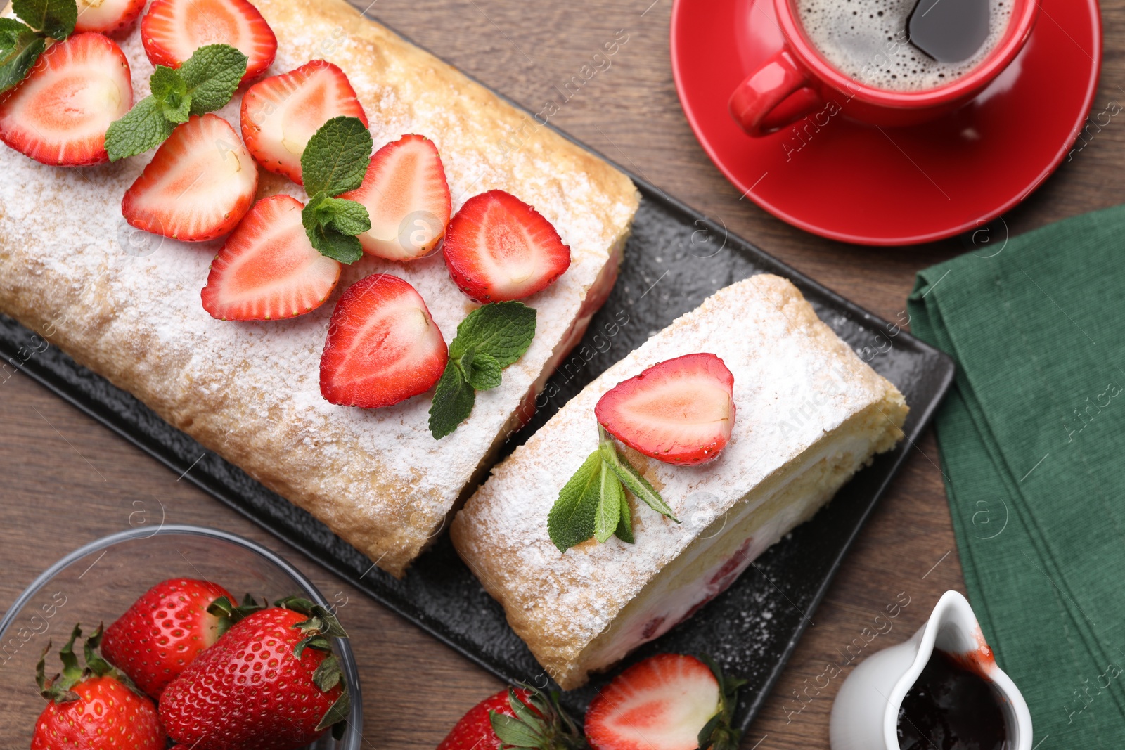 Photo of Delicious cake roll with strawberries and cream served on table, flat lay