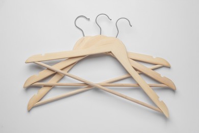 Photo of Empty wooden hangers on light grey background, top view