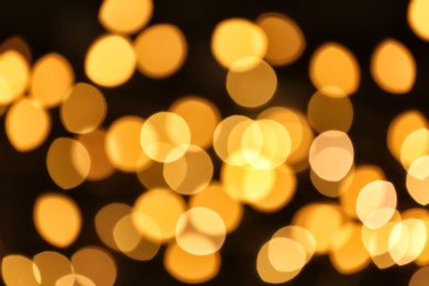 Photo of Beautiful golden lights on dark background. Bokeh effect