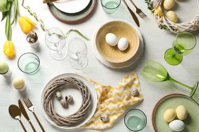 Festive Easter table setting with eggs on wooden background, top view