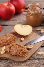 Photo of Fresh apples with peanut butter on wooden table