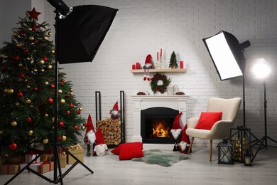 Beautiful Christmas themed photo zone with professional equipment, tree and fireplace in room