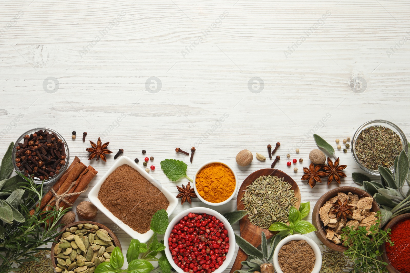 Photo of Different fresh herbs and spices on white wooden table, flat lay. Space for text