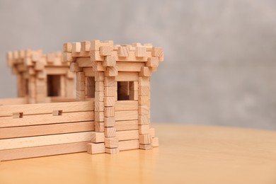 Photo of Wooden fortress on table against grey background, space for text. Children's toy