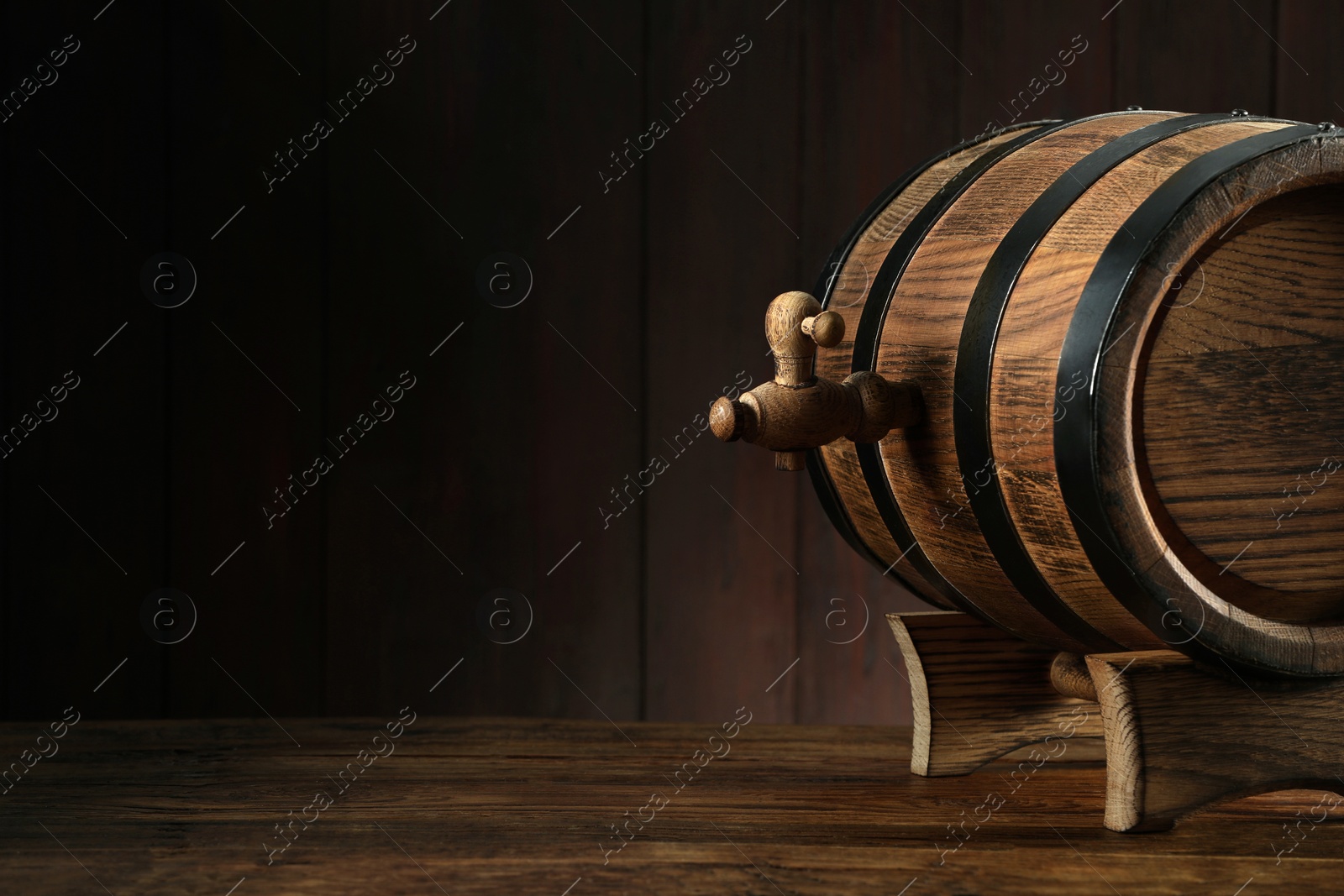 Photo of Wooden barrel with tap on table near wall. Space for text