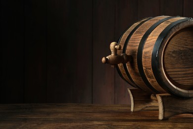 Photo of Wooden barrel with tap on table near wall. Space for text