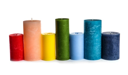 Different colorful wax candles on white background