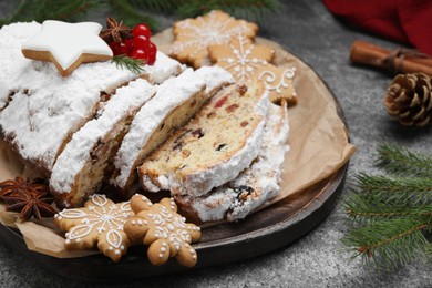 Photo of Traditional Christmas Stollen with icing sugar on grey table