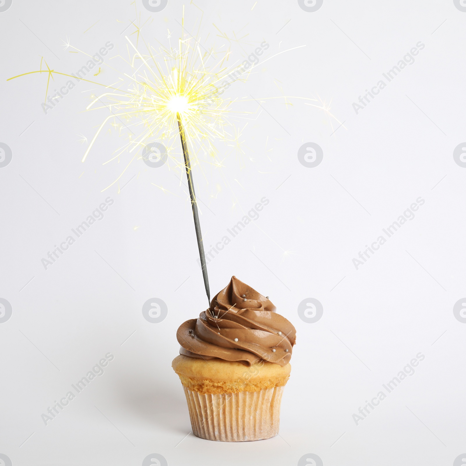 Image of Birthday cupcake with sparkler on white background